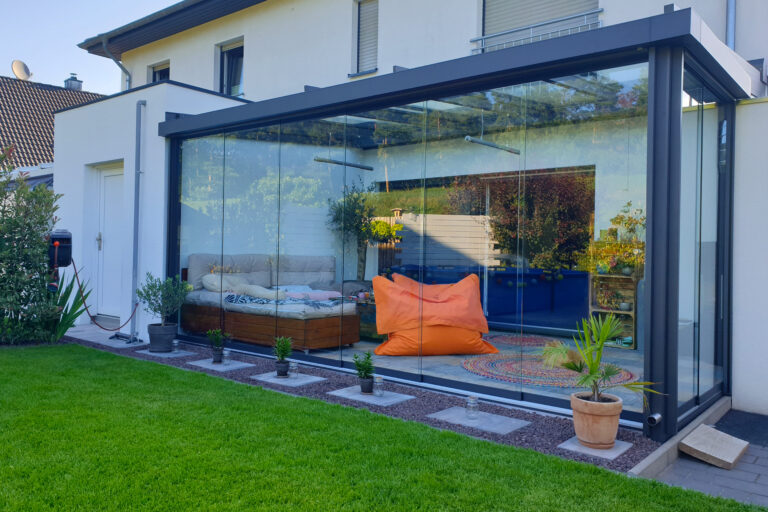 Wintergarten Serr, HeatTube- der schlanke Infrarotheizstrahler passt ich auch hier im Bild in das puristische Design des Sommergartens ein. Zusammen mit schicken Möbel ist es ein Ort zum Wohlfühlen.